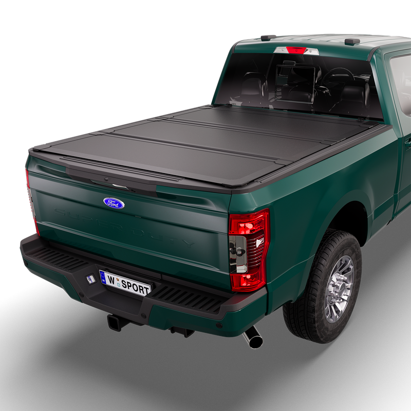 Worksport NEXUS hard folding tonneau cover on a pickup: 3D studio render of a green Ford F-250/F-350 Super Duty from the rear quarter with a black NEXUS hard folding tonneau cover closed, all three panels flat over the bed