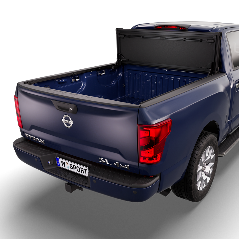 Worksport NEXUS hard folding tonneau cover on a pickup: studio render of a dark blue Nissan Titan SL 4x4 from the rear quarter with a black NEXUS hard folding tonneau cover flipped up vertical against the cab, bed fully open