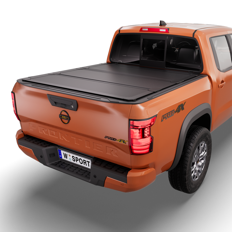 Worksport NEXUS hard folding tonneau cover on a pickup: 3D studio render of an orange Nissan Frontier from the rear quarter with a black NEXUS hard folding tonneau cover closed, all three panels flat over the bed