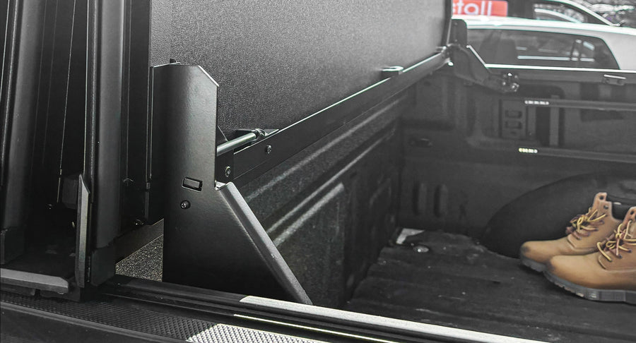 Worksport NEXUS hard folding tonneau cover folded and flipped up behind the cab, the bed open, gear loaded in the bed
